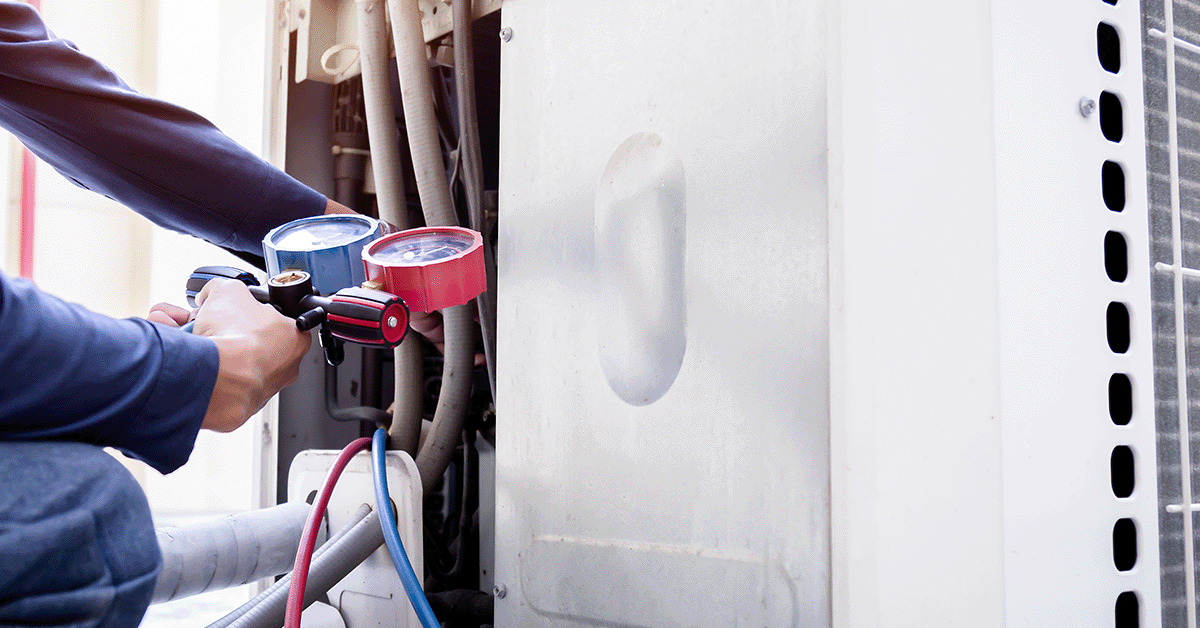 Technician examining rooftop Air condition unit